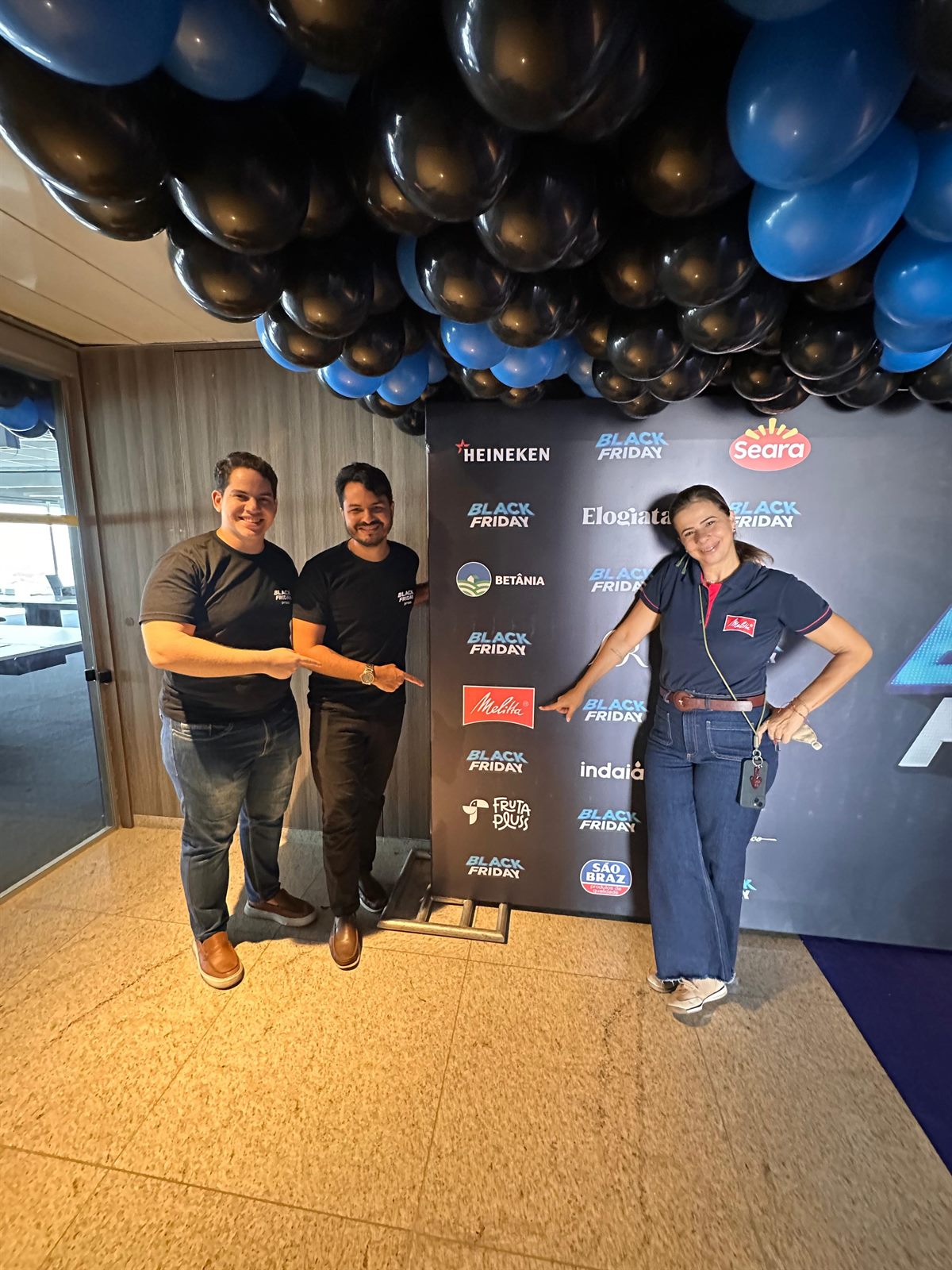 Equipe da Praso em evento de marca com decoração azul e preta