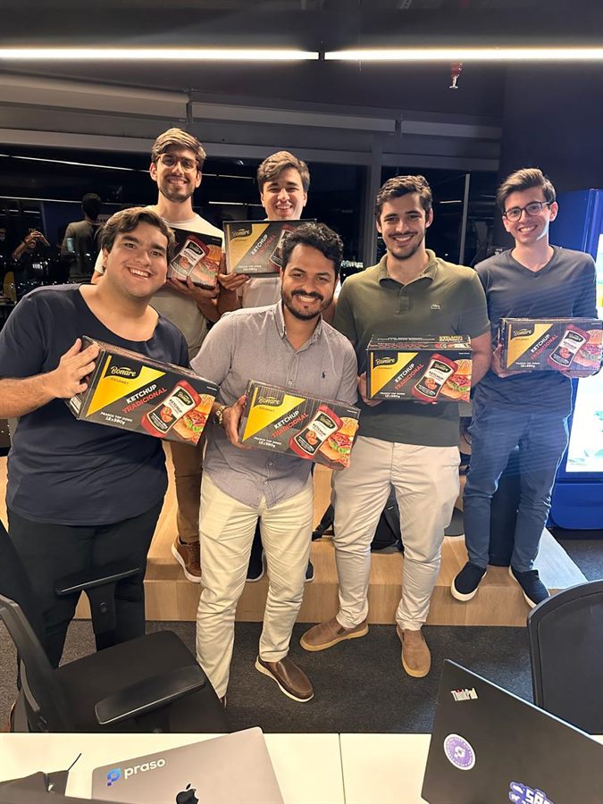 Colaboradores da Praso em campanha interna segurando brindes
